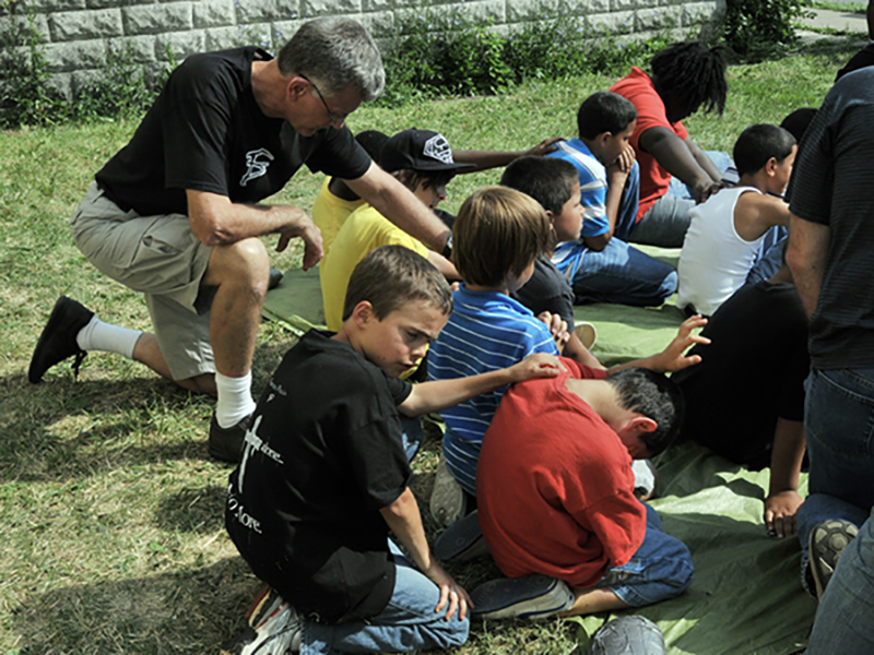 Norm and Sam praying with kids in Buffalo