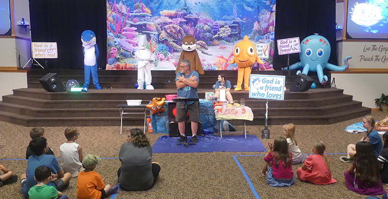 Rob teach in front of Sea Animal Mascots at VBS